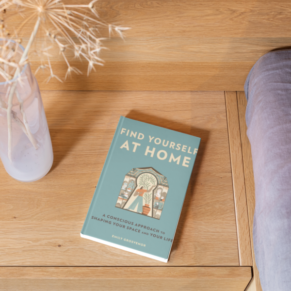 Find Yourself At Home Book sitting on a nightside table beside a bed and a vase of flowers