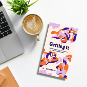 Getting It book on a desk that has coffee and a laptop