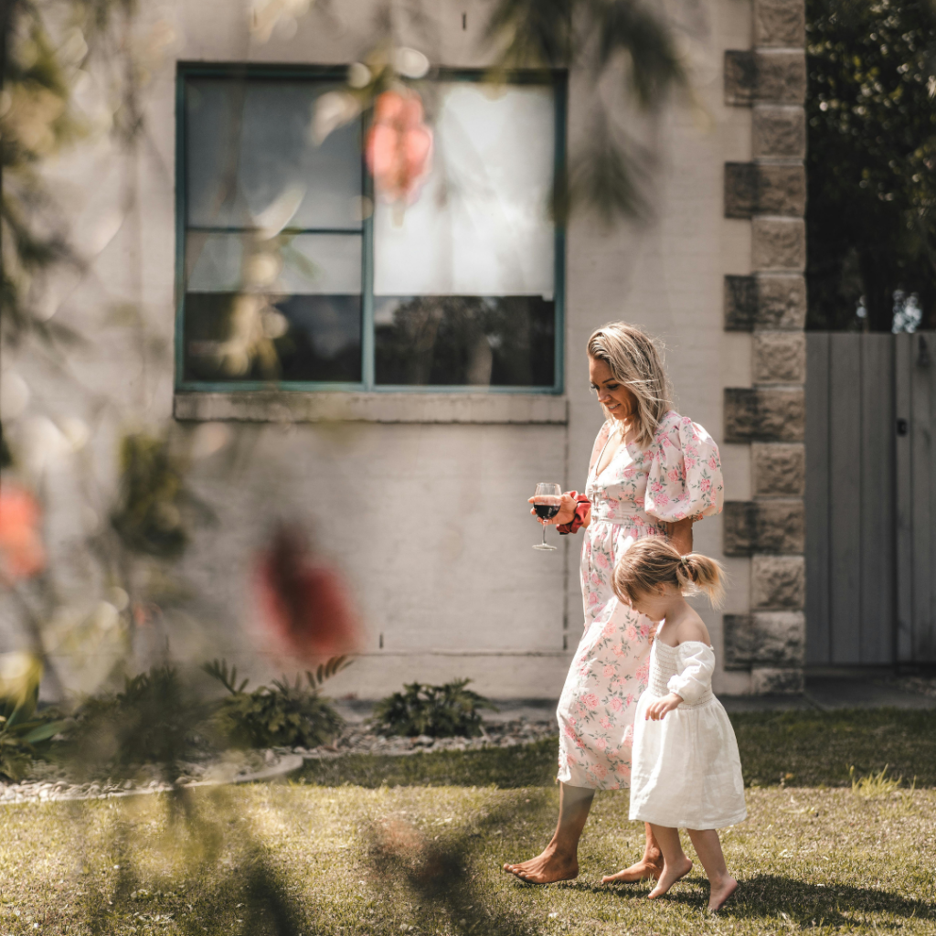 A mother and daughter dressed up walking through the yard to celebrate Mother's Day on a beautiful spring day